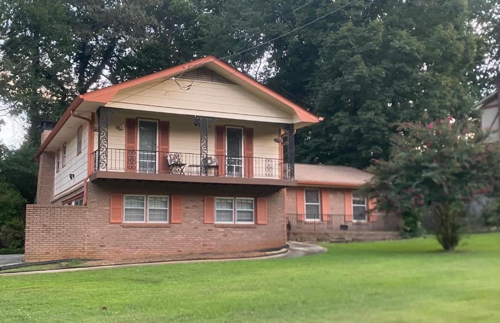 a brick house with a balcony on top of it at Peaceful 4BR Haven in Stn Mtn GA in Stone Mountain