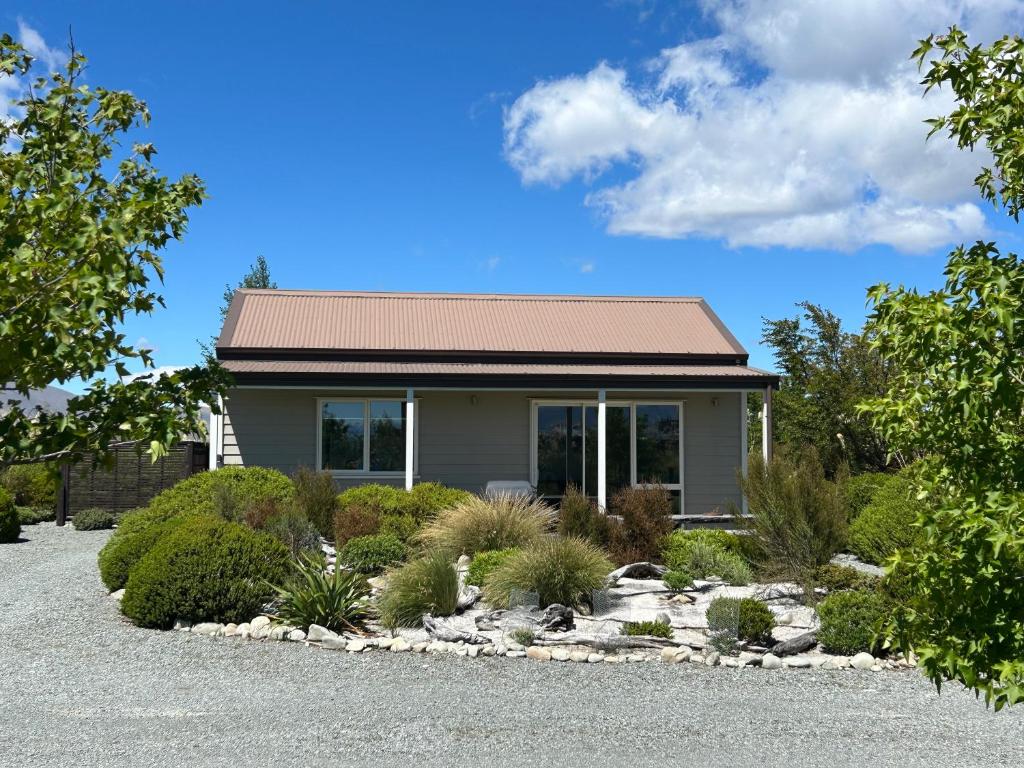a house with a gravel yard in front of it at Mahina Cottage in Twizel