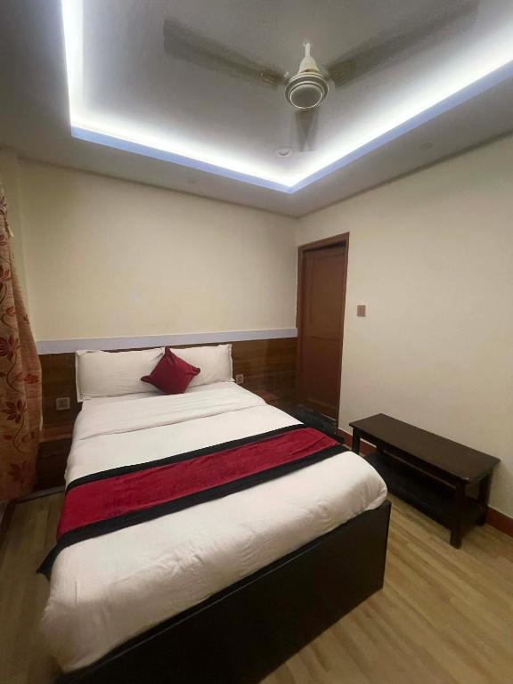 a bedroom with a bed with a red pillow on it at New milan guest house in Kathmandu