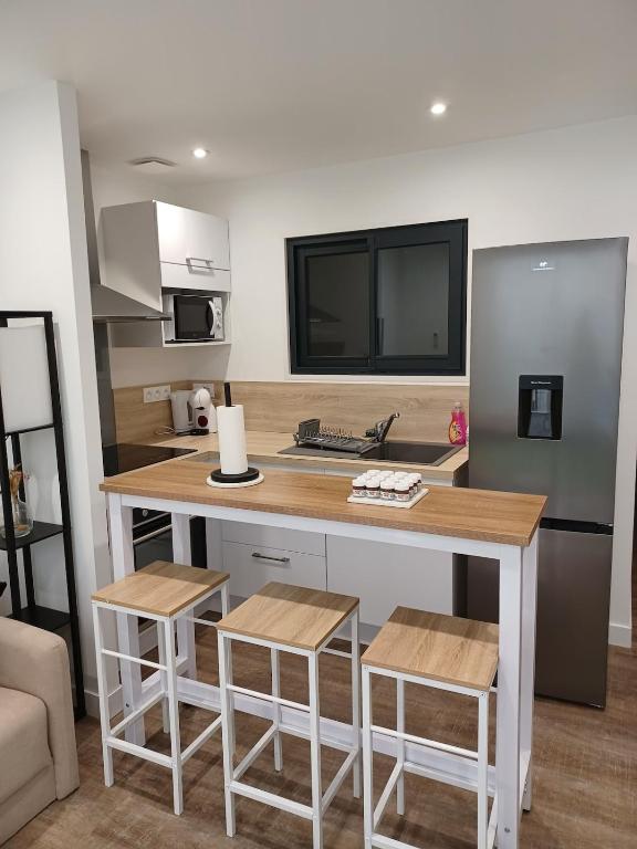 a kitchen with a table and stools in a room at Le Doudou, Charmant T2 avec Terrasse et Climatisation in Marmande