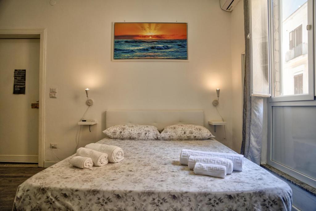a bedroom with a bed with rolled towels on it at Monolocale City Station in Brindisi