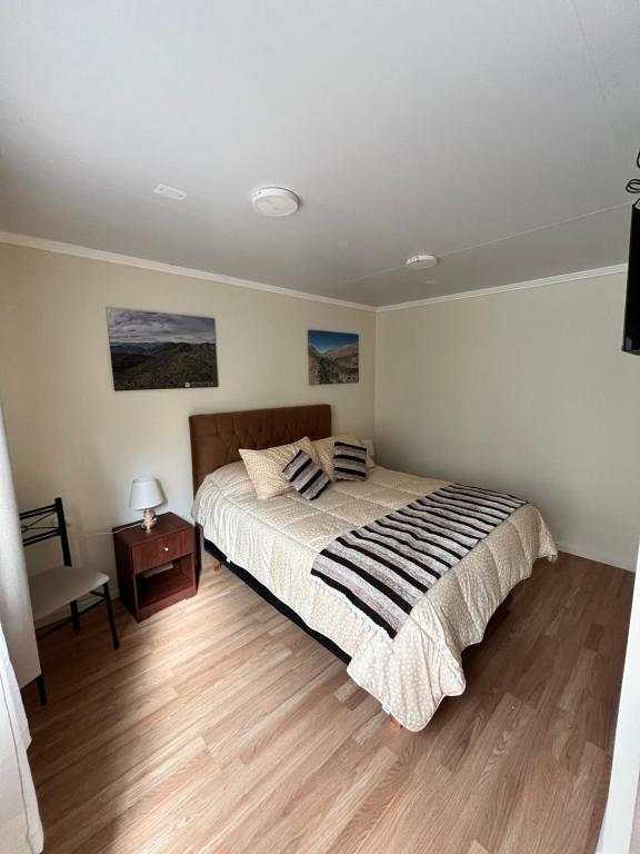 a bedroom with a bed and a wooden floor at Nueva Carrera in Illapel