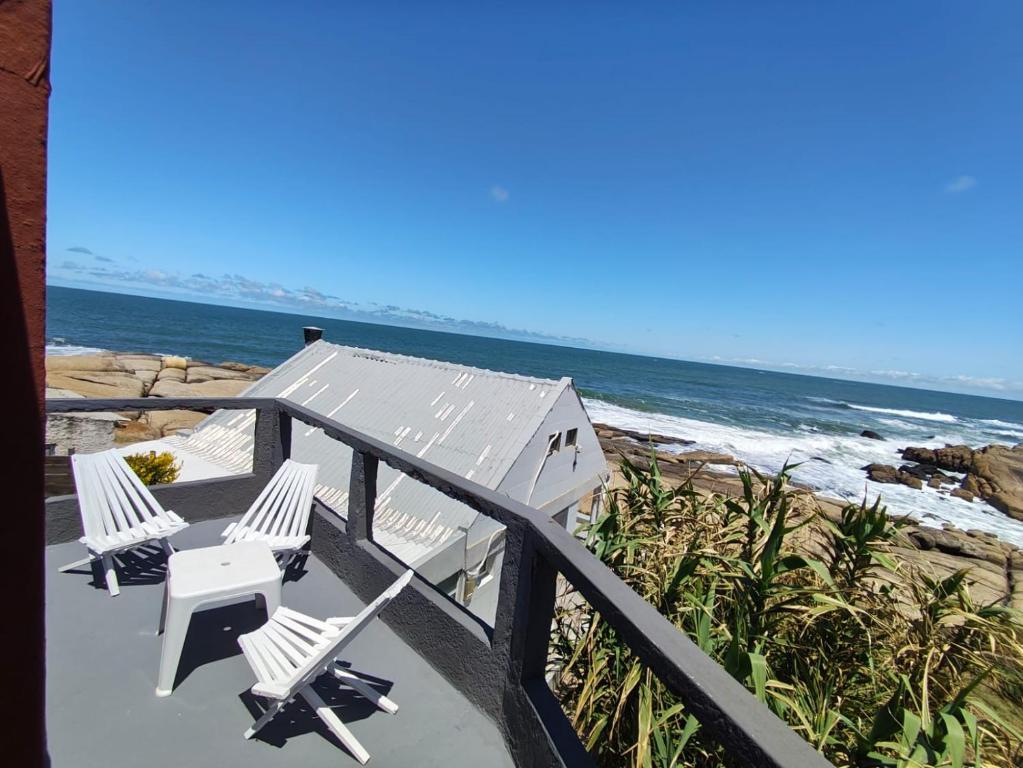 a balcony with two chairs and the beach at Eywa in Punta Del Diablo