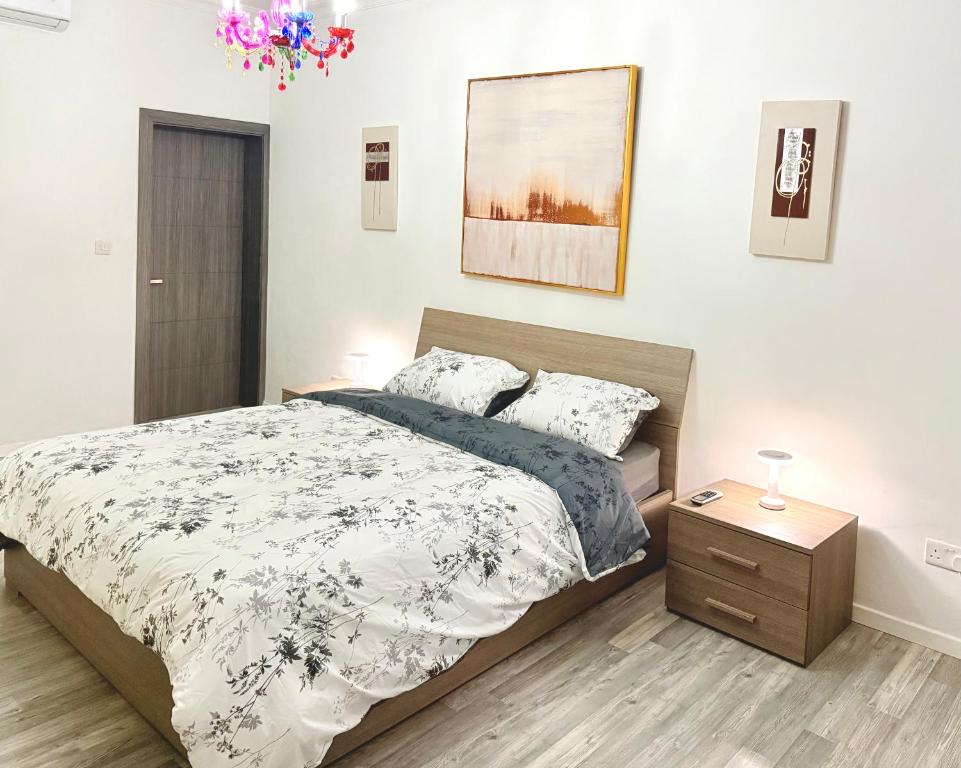 a bedroom with a large bed and a night stand at Room in sliema's heart in Il-Gżira
