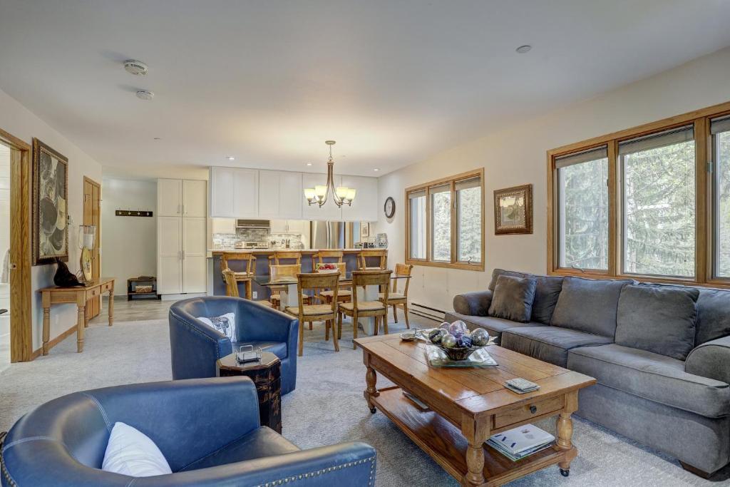 a living room with blue couches and a table at Townsend Place, A Vail Resorts Property in Beaver Creek