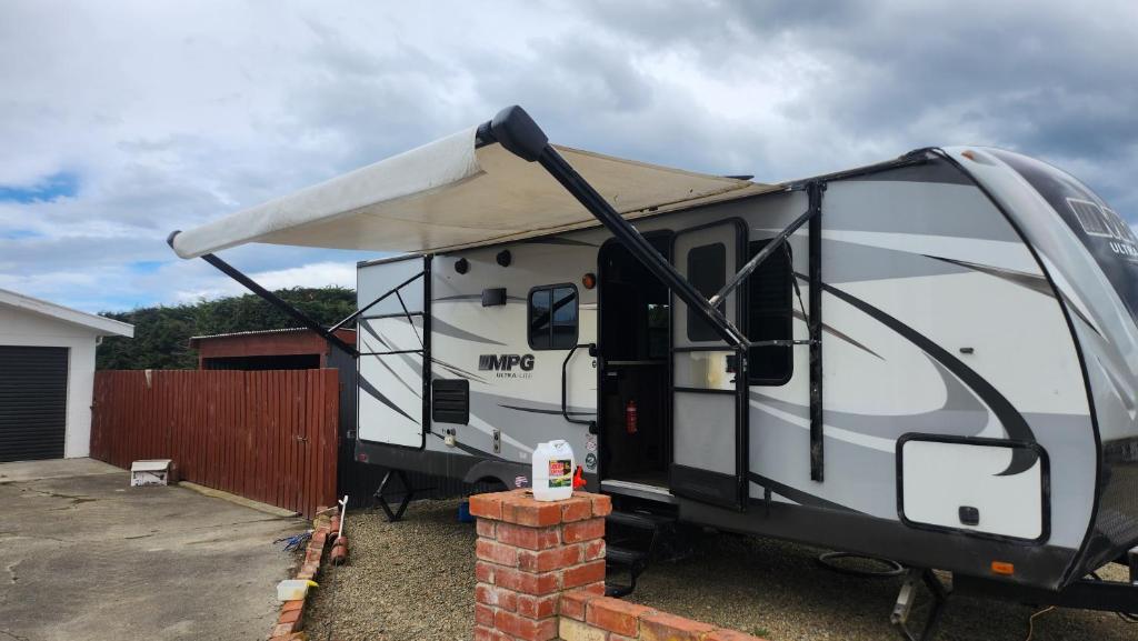 a black and white trailer parked in a driveway at Rattrays Rd Farm Accomodation in Makikihi
