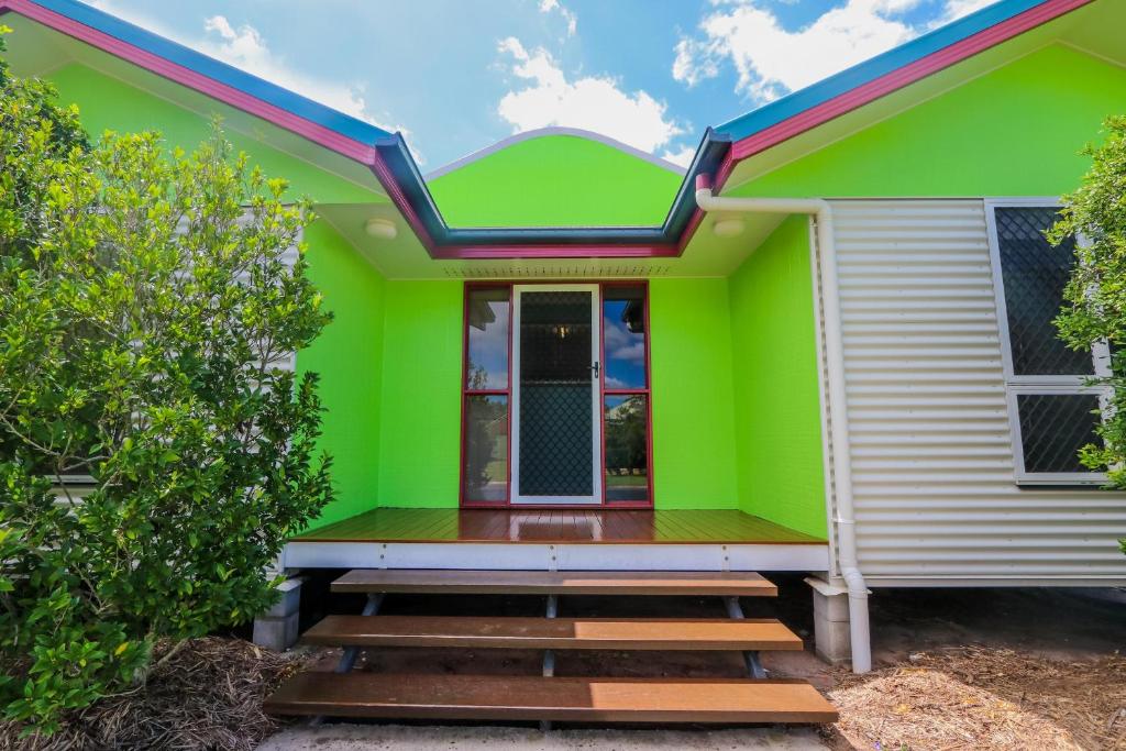 a green and white house with stairs in front at McLeods • Pet-Friendly Central Beach House for 6 in Agnes Water