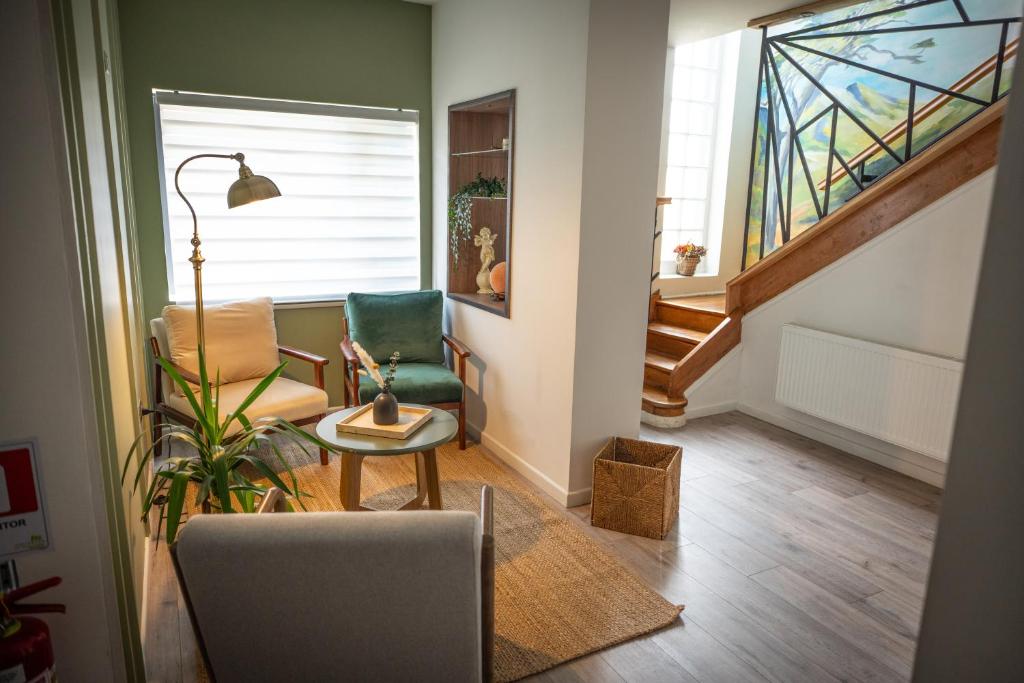 a living room with two chairs and a stair case at Hotel Auramia in Punta Arenas