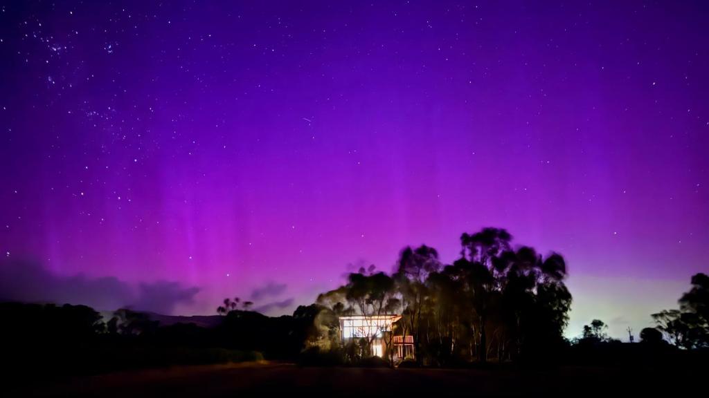 an aurora in the sky over a house at The Treehouse at Sellicks Hill in Sellicks Hill