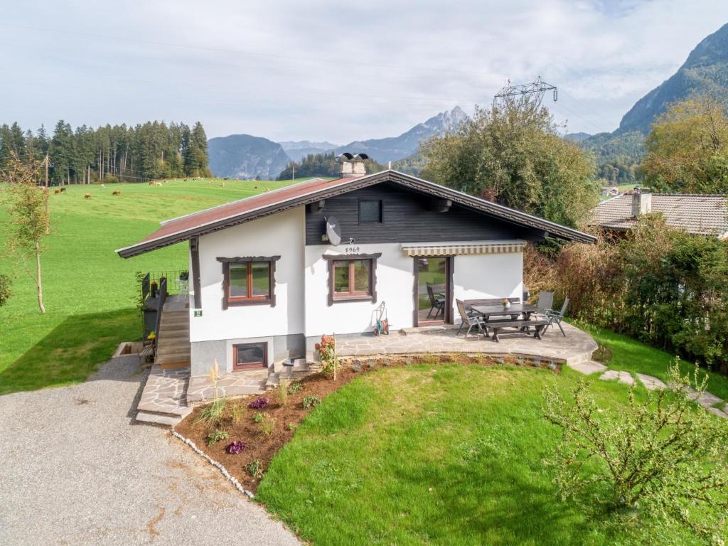 a small white house with a patio and a yard at Chalet Pölven in Schwoich