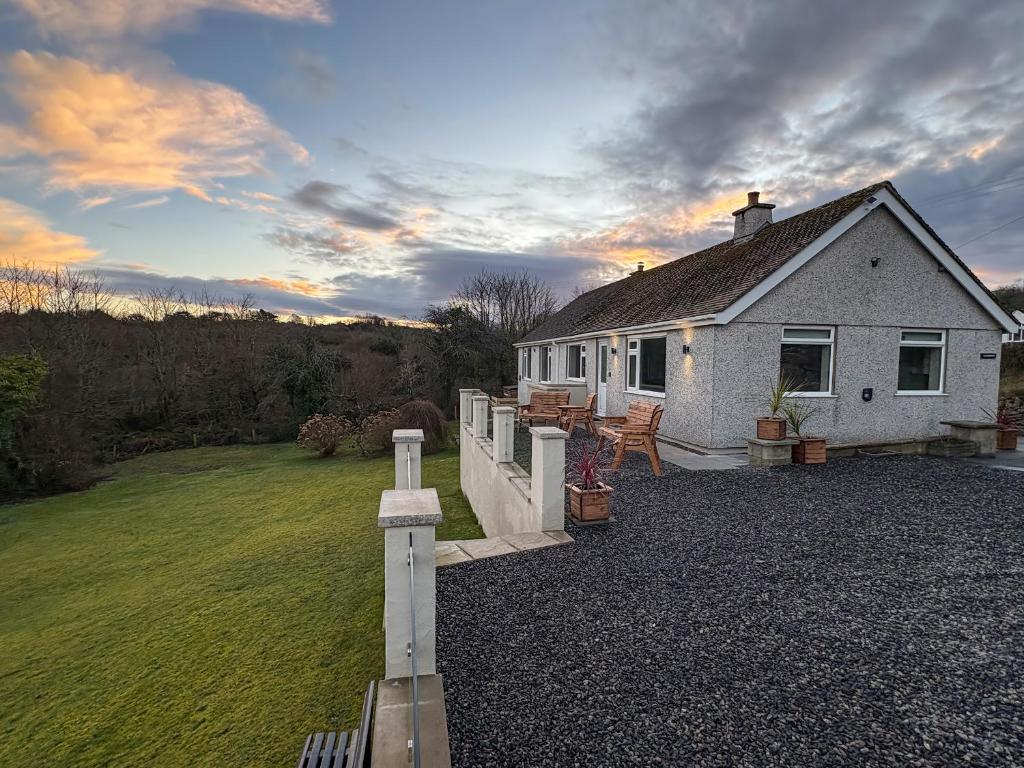 a small white house with a yard and a lawn at Caledfryn in Benllech