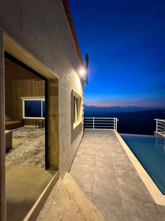 ein Balkon eines Hauses mit Blick auf das Meer in der Unterkunft Aroma Chalet in Ḩūmīn al Fawqā