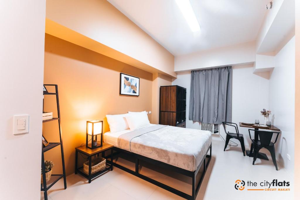 a bedroom with a bed and a desk and a table at The City Flats Circuit in Manila