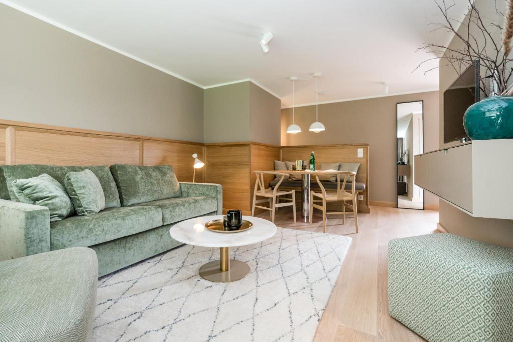 ein Wohnzimmer mit einer grünen Couch und einem Tisch in der Unterkunft Green Kööv in Wenningstedt-Braderup