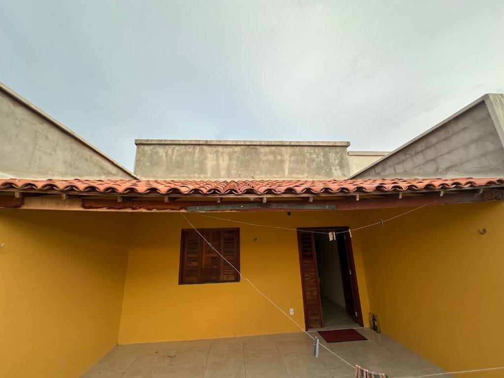 a yellow house with a red roof at Casa Amarela no Fortim in Fortim