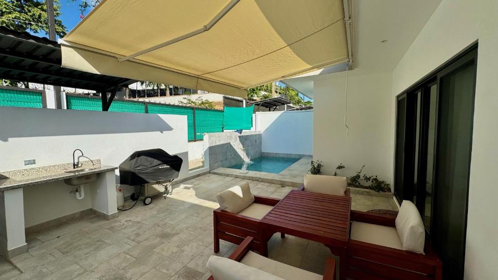 eine Terrasse mit Tisch, Spüle und Pool in der Unterkunft Casa de Lemon in Coco