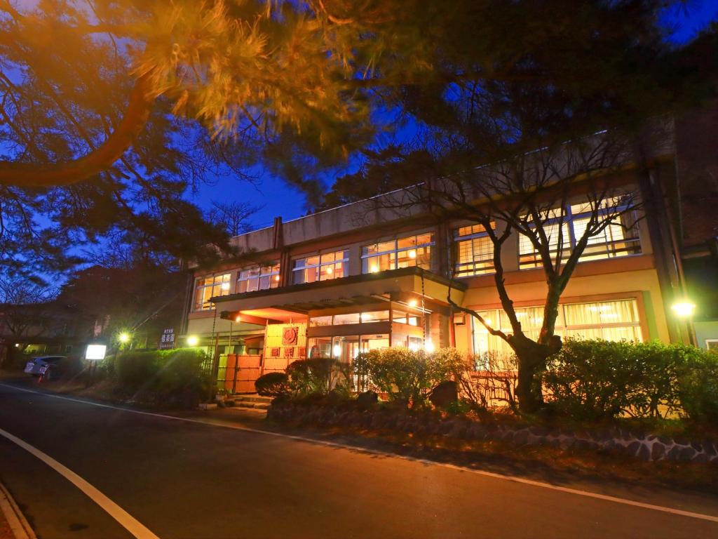 a lit up building on a street at night at 偕楽園 in Shirasaka