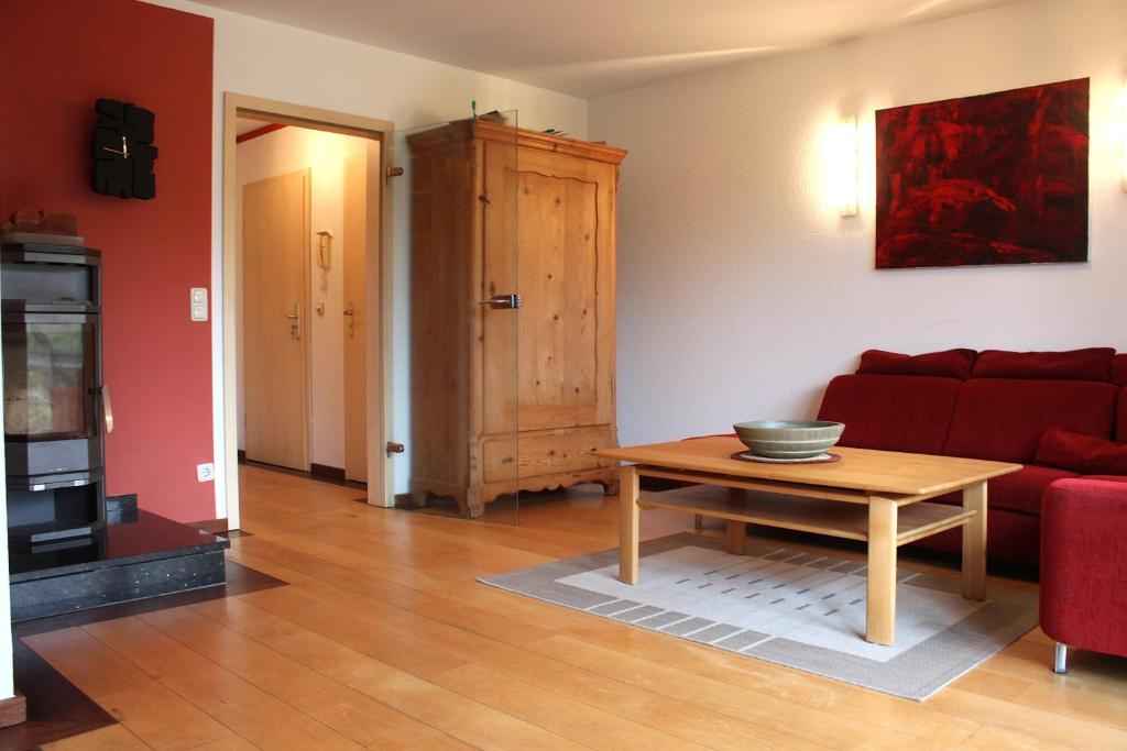 a living room with a red couch and a table at Gerdemann in Timmendorf