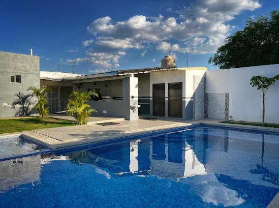 ein Haus mit einem Swimmingpool vor dem Haus in der Unterkunft Finca Cuexco in Cuescomatitlán