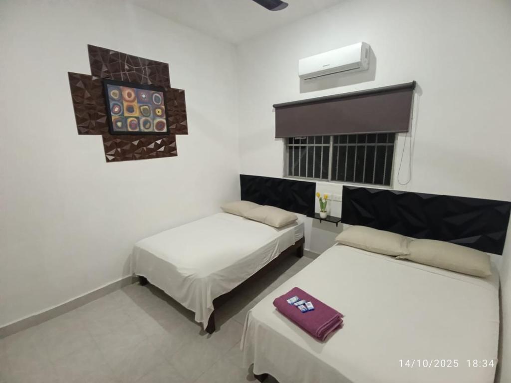 a room with two beds and a heater and avisor at Hotel y Hostal AH MUN in Mérida