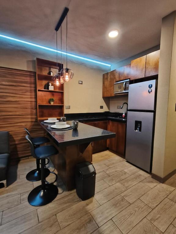 a kitchen with a island and a refrigerator at Loft moderno y acogedor in Durango