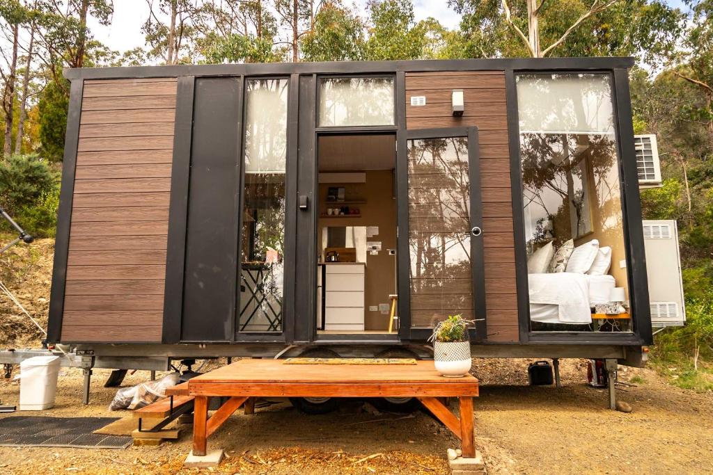 a tiny house on a trailer with a table at Wattle Grove Hideaway by Tiny Away in Wattle Grove