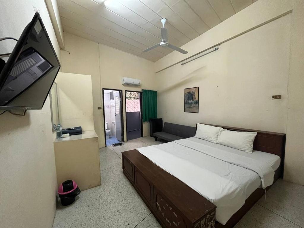 a bedroom with a bed and a flat screen tv at room 102 in Wanna Apt in Pattaya