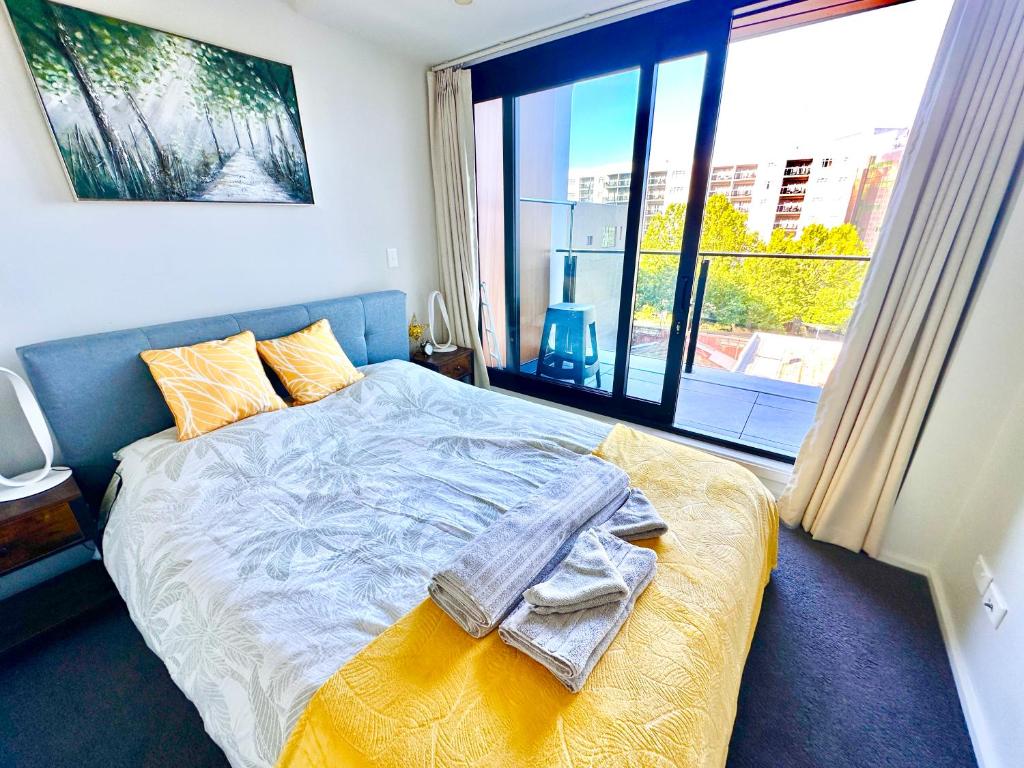 a bedroom with a bed and a large window at Connect 204 in Auckland