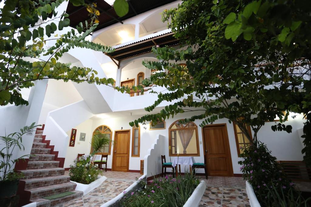 un patio de una casa con escaleras y árboles en The Galapagos Pearl B&B, en Puerto Ayora