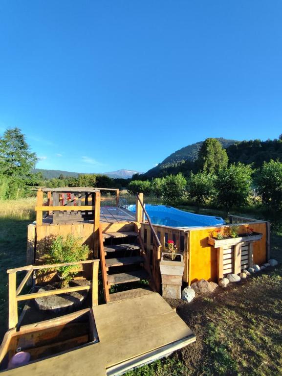 a house with a deck and stairs in the grass at Cabaña Bellavista in Manzanar