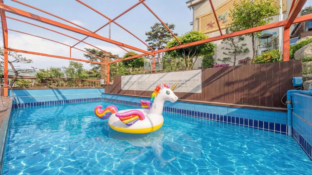 a pool with a unicorn float in a swimming pool at Gangwha Jeongwon Pension in Incheon
