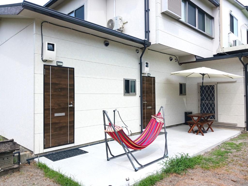 a patio with a chair and an umbrella at 別館JOUNi in Niijimamura