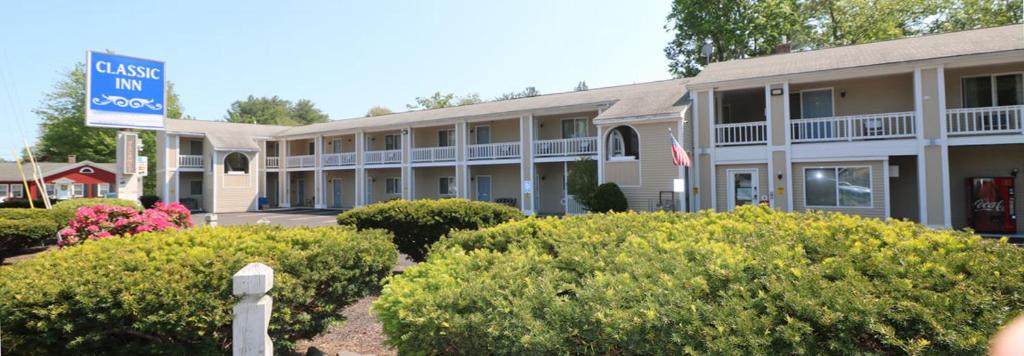 a hotel with bushes in front of a building at Classic Inn in Saco