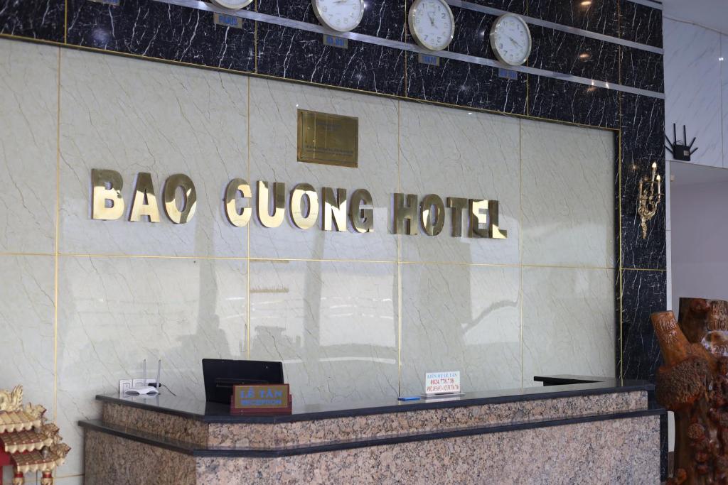 a bag giving hotel sign on a wall with clocks at Bảo Cường Hotel in Hương Hóa
