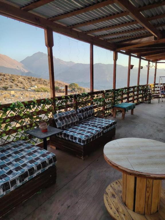 a patio with couches and tables and a view of the mountains at Casona Mamalluca in El Durazno