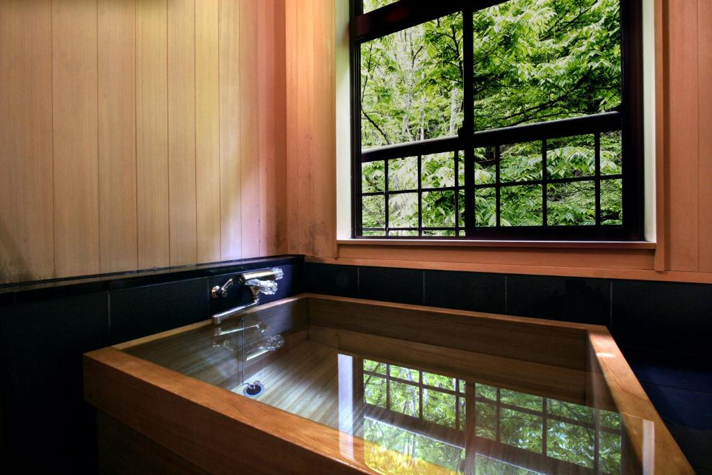 a bathroom with a sink and a window at Hinanoyado Chitose in Tokamachi