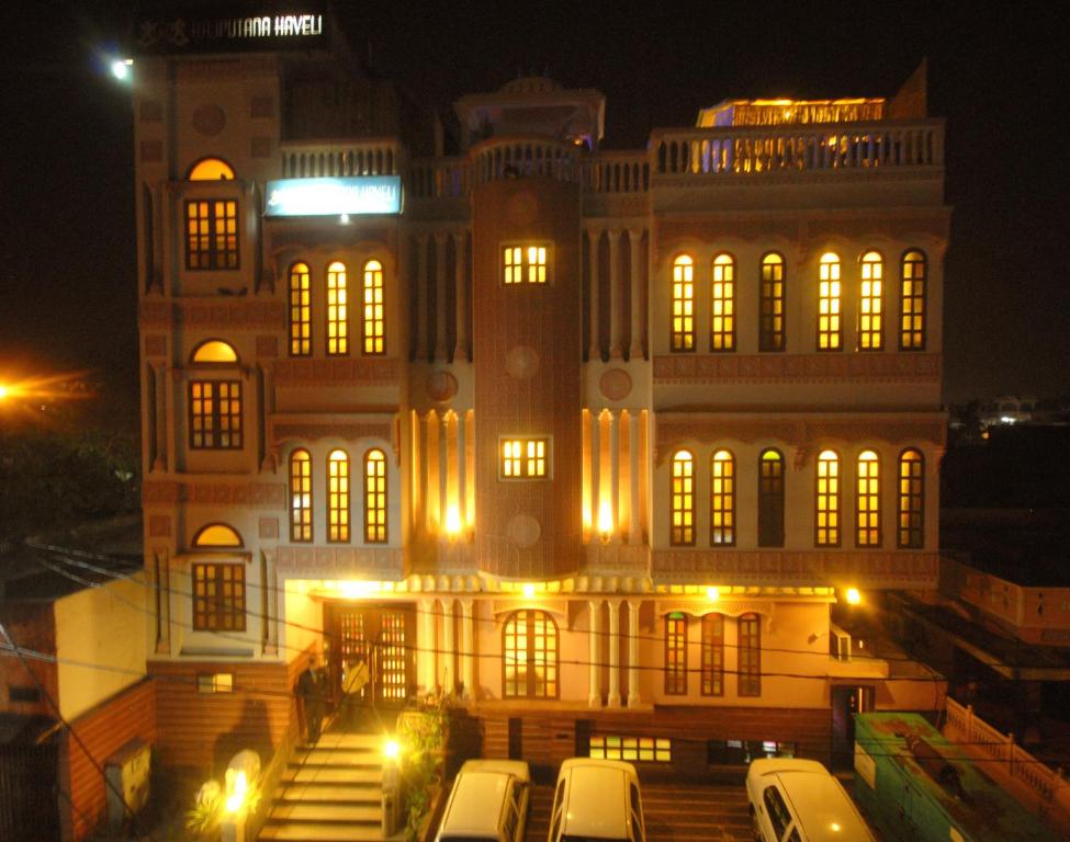 a building with cars parked in front of it at night at Rajputana Haveli in Jaipur
