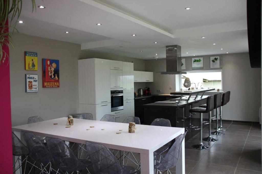 a kitchen with a white table and black appliances at Gîte d'olympe in Graffigny-Chemin