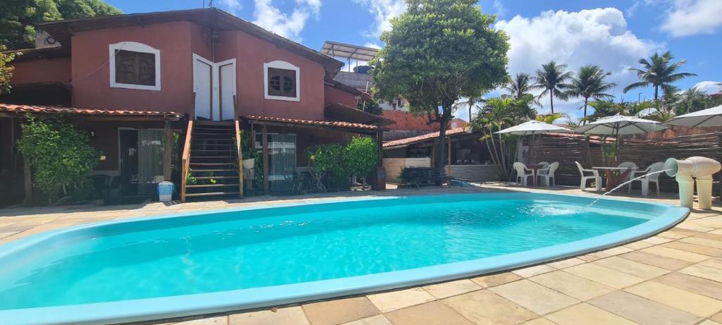 a swimming pool in front of a house at Chalé Beija Flor in Praia do Frances