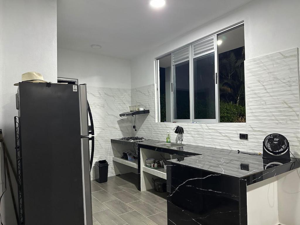a kitchen with a black refrigerator and a window at Finca Villeta in Villeta