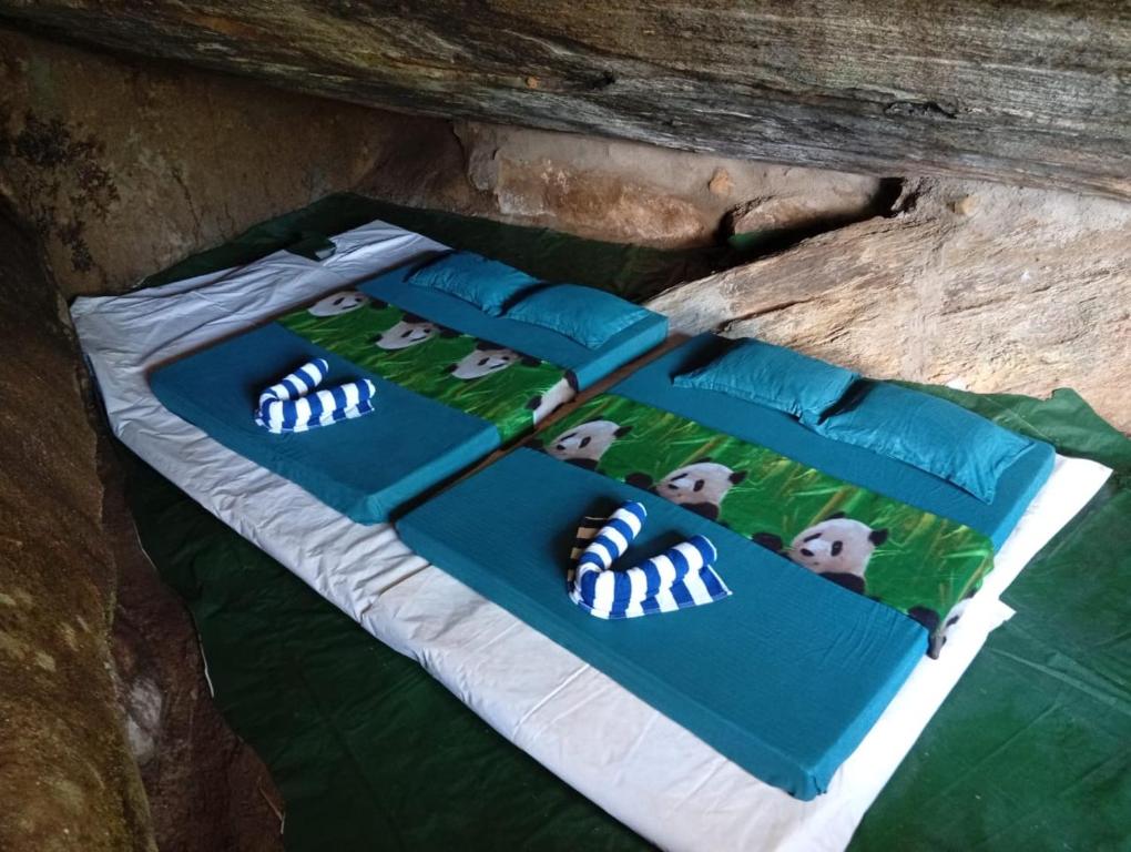 a group of pillows on a bed in a cave at Sinharaja-Forest Cave Camp in Ullinduwawa
