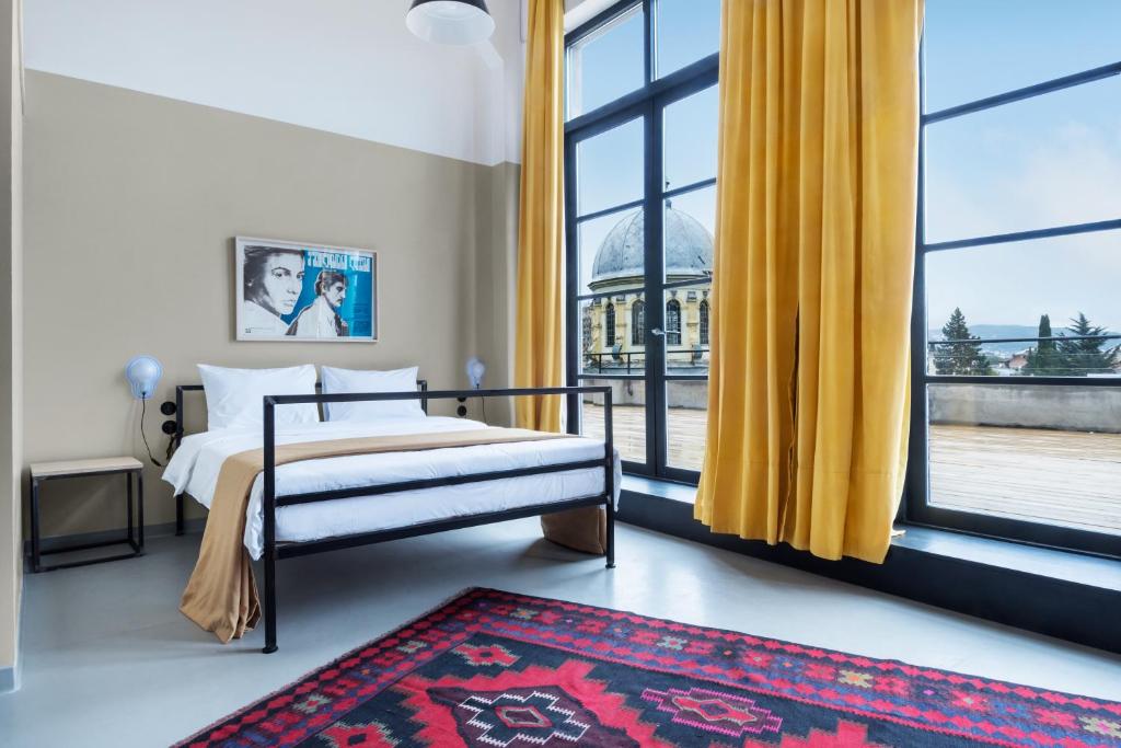 a bedroom with a bed and a window at Fabrika Hostel & Suites in Tbilisi City