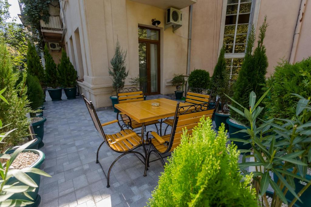 eine Terrasse mit einem Tisch, Stühlen und Pflanzen in der Unterkunft Mais Guest House in Tbilisi City