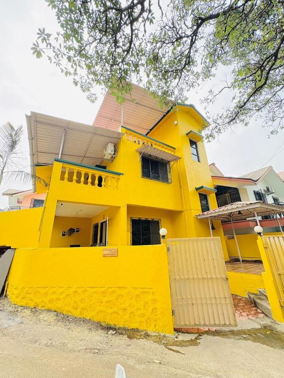 a yellow house with a yellow fence in front of it at Between The Raindrops in Lonavala
