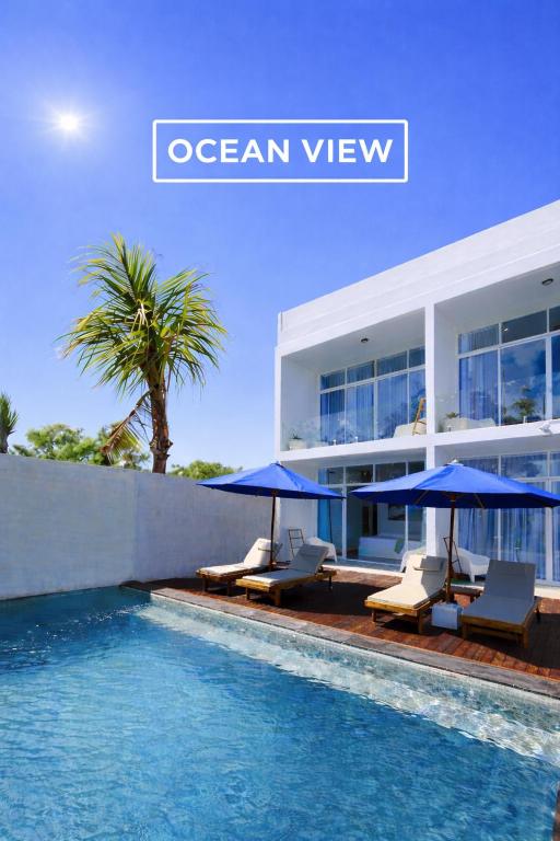 an ocean view villa with blue umbrellas and a swimming pool at ELEVATE - Uluwatu, Bali in Uluwatu
