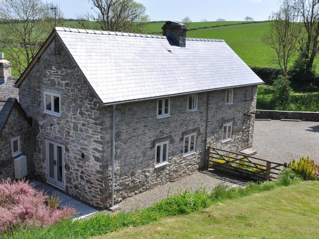 an old stone house with a metal roof at Rockhill Farmhouse in Craven Arms
