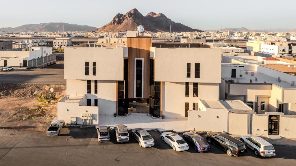 a group of cars parked in a parking lot in front of a building at المحروسة للشقق المفروشة Mahrousa Apartment in Medina