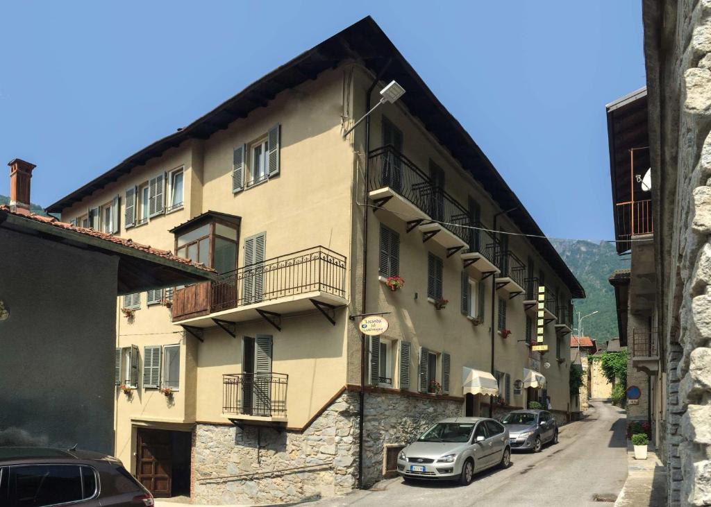 a building with cars parked on the side of a street at Albergo La Pace in Pradleve