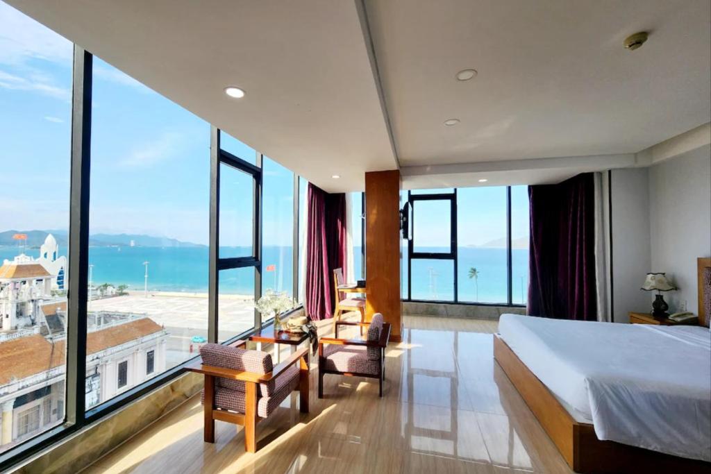 a hotel room with a bed and a view of the ocean at Happy Light Central Nha Trang in Nha Trang