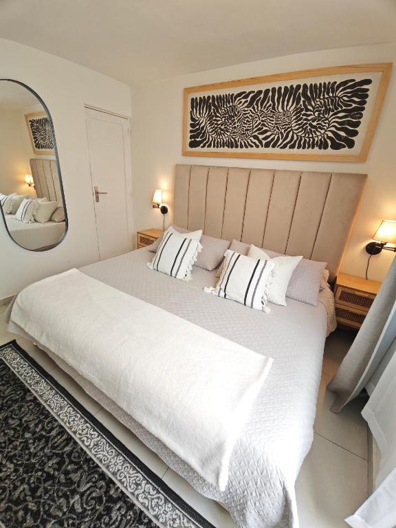 a bedroom with a large white bed and a mirror at Comfy Habitación en Puebla! in San Baltasar